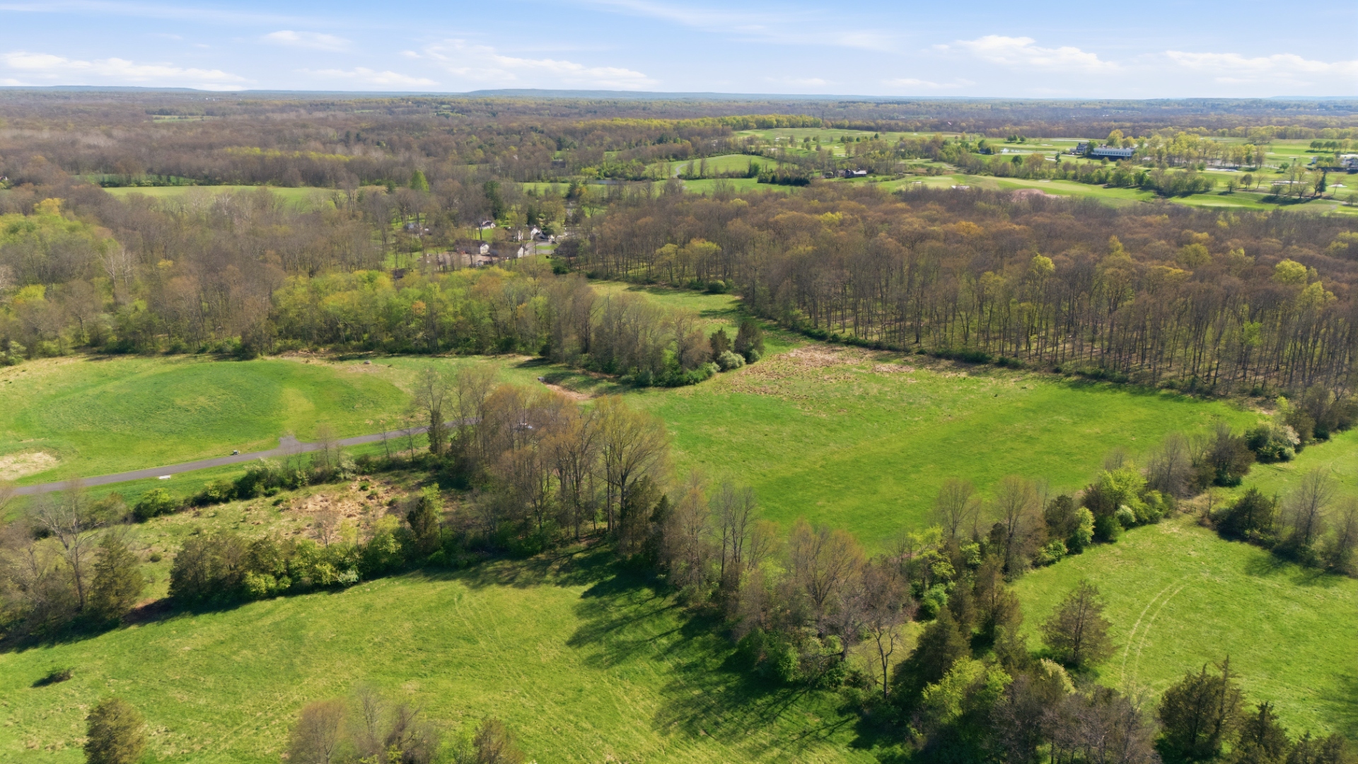 Aerial view of open meadowland and hedgerows across the Bedminster Farms parcels in spring
